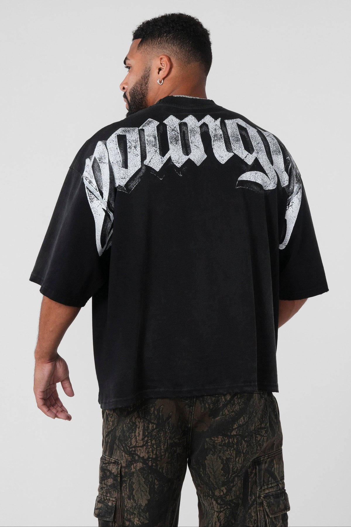 4159 - Huge Tees for Men: Bold gothic logo tee with boxy draped fit, vintage faded 100% cotton, and heavyweight presence in color Black wash