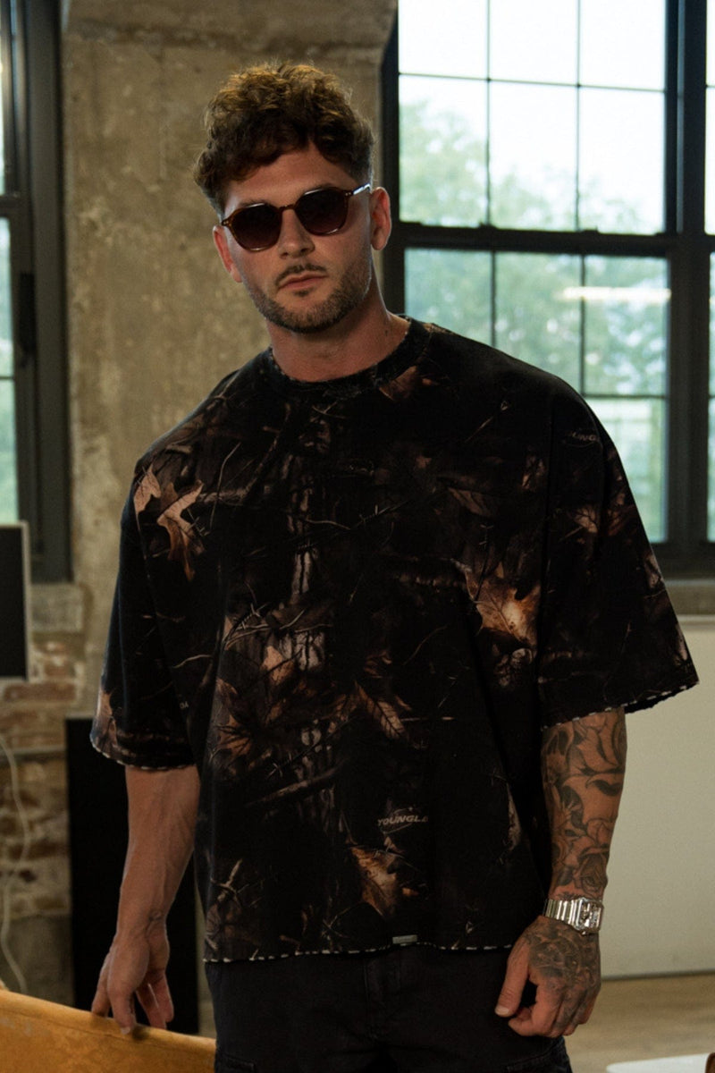 4159 - Huge Tees for Men: Bold gothic logo tee with boxy draped fit, vintage faded 100% cotton, and heavyweight presence in color Black tree Camo.